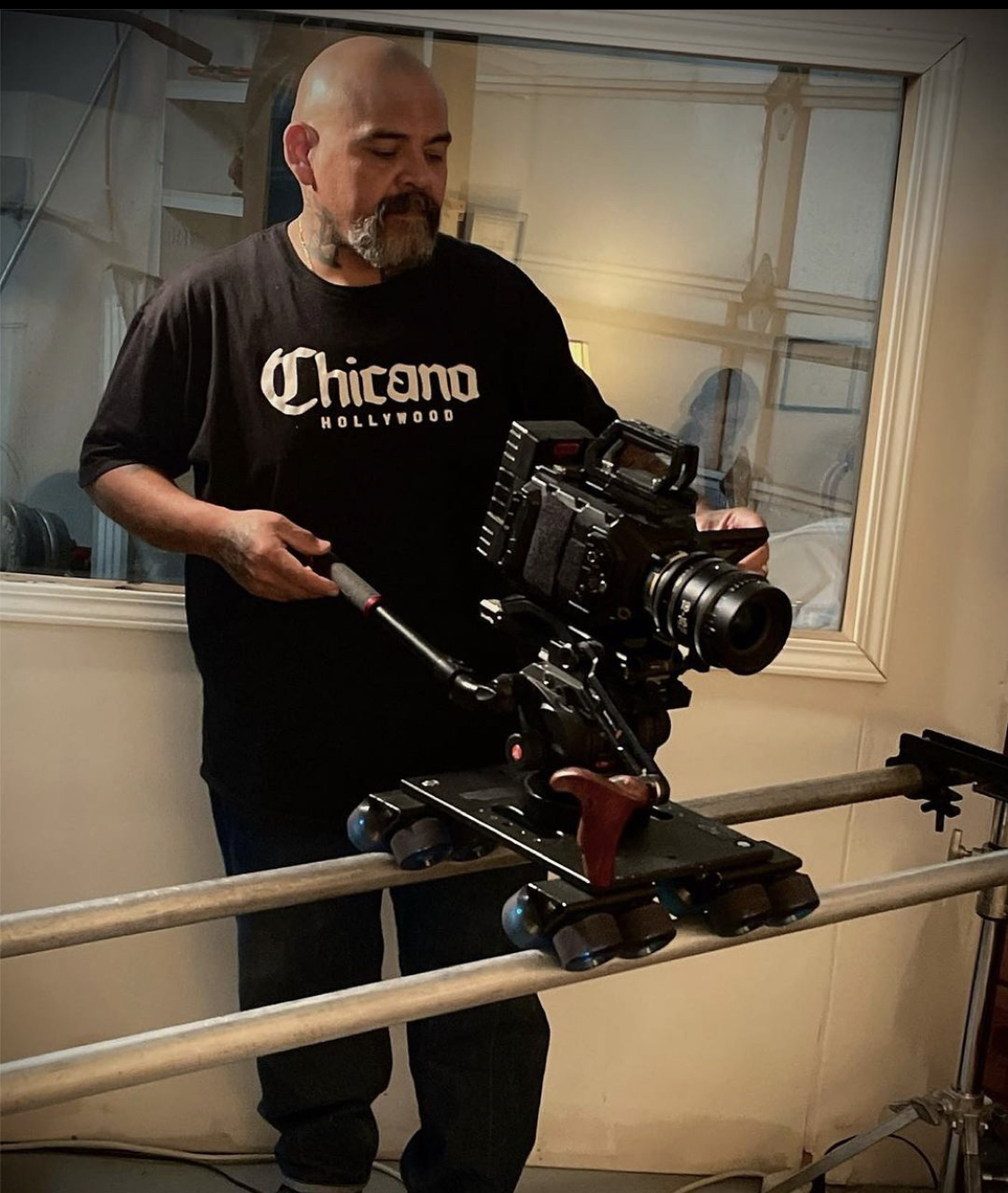 A Chicano filmmaker with a camera on a slider.